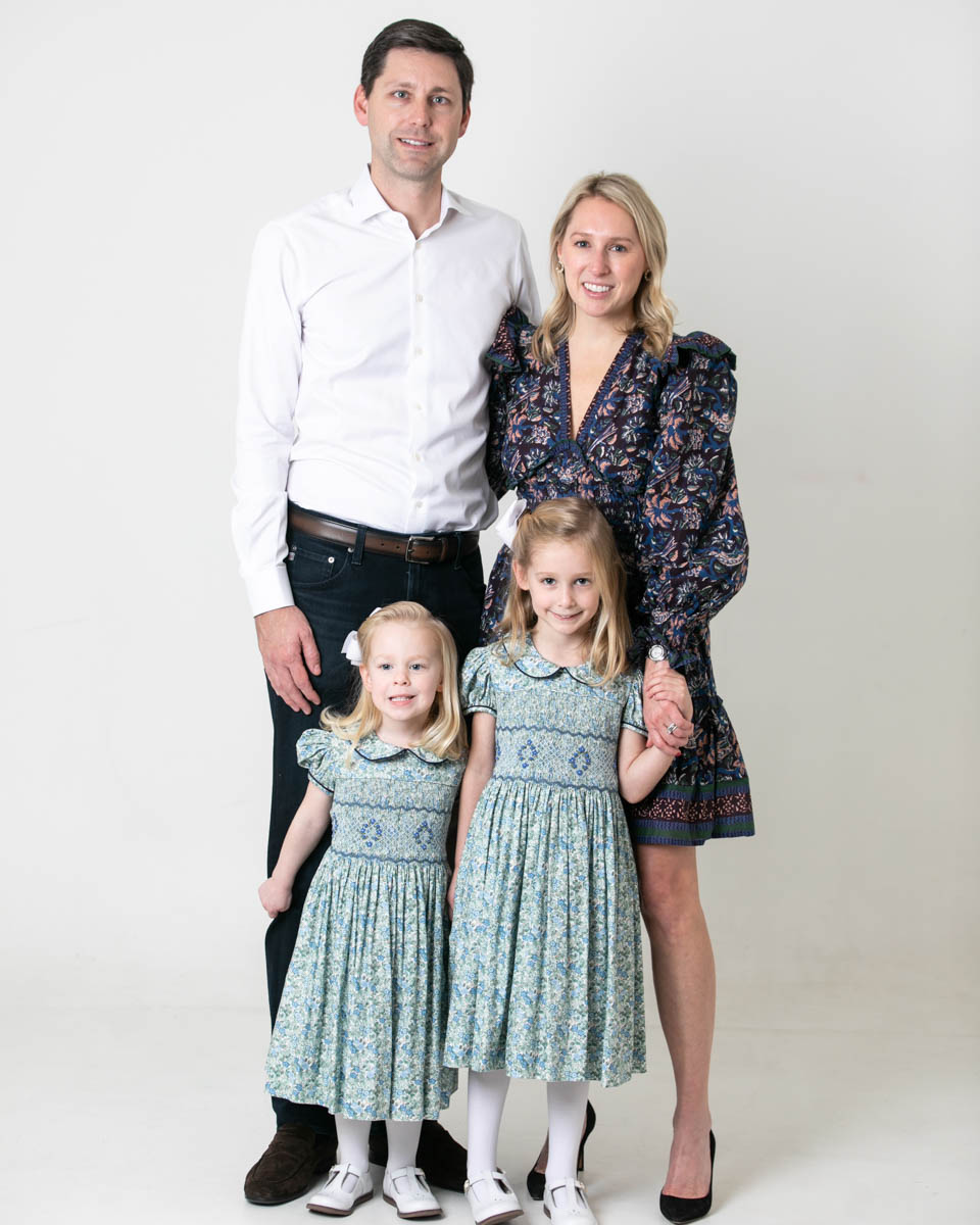 Family of four standing for in studio portrait